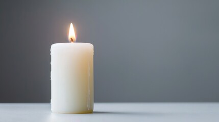 Single white candle flame on white surface