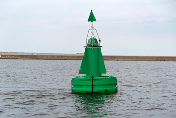 A green buoy on the river marking the fairway in the reservoir.