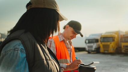Side view of people talking while working in e-commerce and retail logistics. Female holding ward drink with one hand. Man asking important questions about truck. Safety inspection.