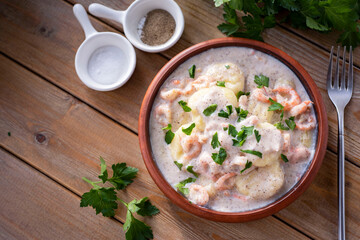 Dumplings with shrimp in cream sauce for lunch on a wooden table. Close-up.