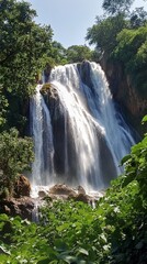 Obraz premium Majestic Waterfall in Lush Green Forest: A Breathtaking Natural Wonder