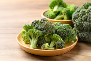 Organic raw broccoli on wooden plate, Fresh vegetables, Healthy food ingredient