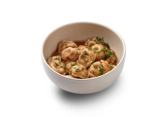 A bowl of traditional pelmeni dumplings served in a rich broth with fresh dill.