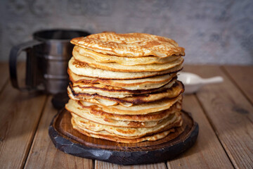 A stack of thin large pancakes on a gray background. A stack of rustic pancakes for breakfast....
