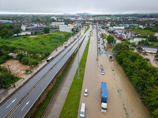 Songkhla,Thailand - 28 Nov 2024: Aerial view of floodwaters inundate roads and vehicles after heavy rainfall.