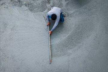 Construction worker smoothing wet cement with a trowel. Building site, concrete work, construction...