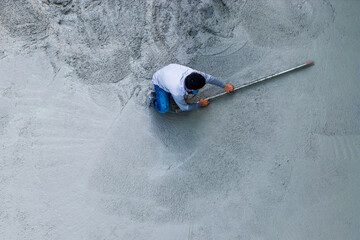 Construction worker smoothing wet cement with a trowel. Building site, concrete work, construction...