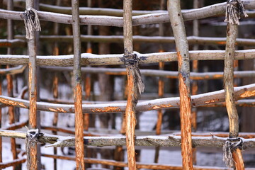 A detailed view of a natural fence made from sticks and branches, ideal for outdoor or nature-themed designs.