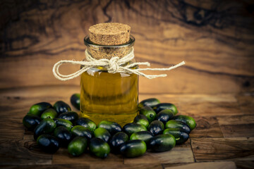 Kalt gepresstes Olivenöl auf Olivenholz