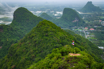 Unique geological formation, Khao Ok Thalu, featuring a natural arch, towering over the surrounding area in Phatthalung, Thailand.
