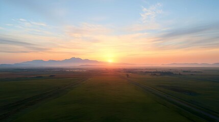 Obraz premium Golden Sunrise Over Misty Green Fields and Rural Landscape