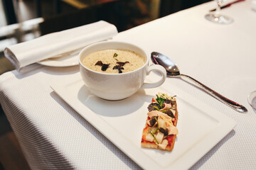 Restaurant serving of French onion soup in a white plate