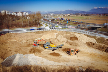 Drone View of Construction Material Stockpile Near Highway Road Construction Site with Heavy Equipment 