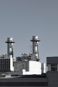 Twin chimneys of a power plant with metallic structures, showcasing industrial energy production.