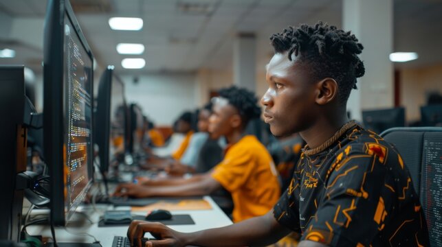 A group of young students focuses intently on computer screens, developing coding skills with a mix of excitement and determination in a modern lab setting.