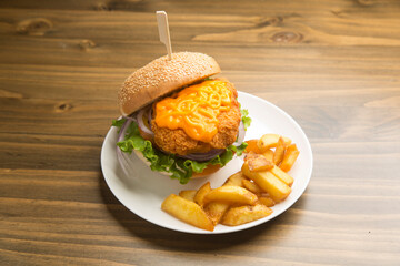 Delicious crispy chicken burger served with melted cheddar cheese, fresh lettuce, red onions, and a side of golden french fries
