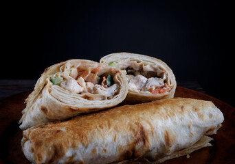 Chicken shawarma on a dark background.