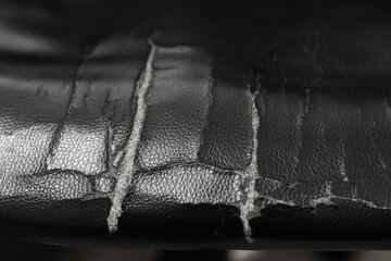 The leather material is torn. Tear damaged old leather brown sofa or chair .background. close up....