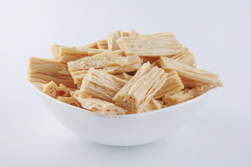 Fuzhu soy sticks in a white plate on a white background. Yuba.