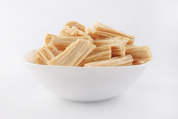 Soy sticks fuzhu in a white plate on a white background. Soy salad. Yuba.