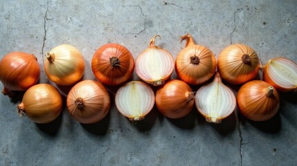 Obraz premium A row of whole and halved onions arranged on a rustic surface