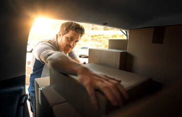 Delivery man loading packages into a van