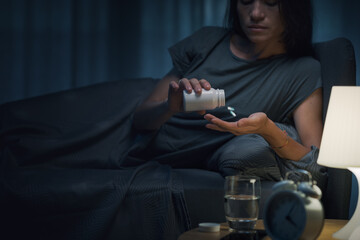 Young woman taking medications at night