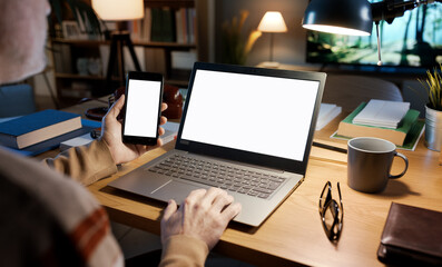 Man getting online using a laptop and a smartphone