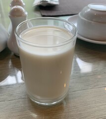 A glass of fresh cow's milk on the dining table for breakfast.