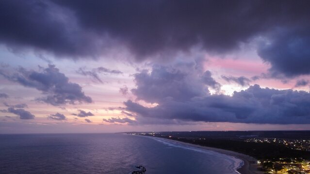 Coastal sunset with vibrant clouds and serene ocean.