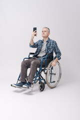 Man in a wheelchair using his smartphone