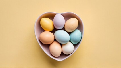 Pastel easter eggs in a heart-shaped bowl on yellow background