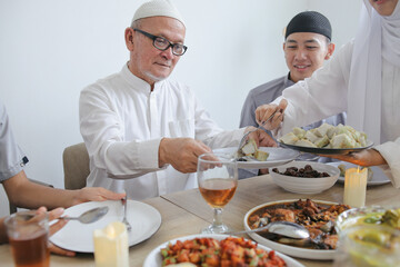Portrait Of Senior Old Muslim Man Receiving Ketupat By His Daughter On Eid Al Fitri Moment