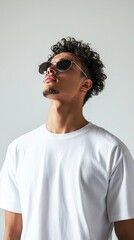 Obraz premium A male fashion model wearing a white oversized t-shirt and sunglasses, in a high-resolution, highly detailed, full-body photo shoot for an editorial in magazine
