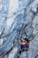 rock climber girl. strong girl. climber climbs to the top of the mountain.