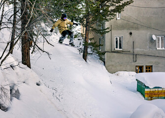 Snowboarder jumping in the forest