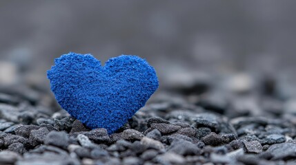 Obraz premium Blue Glittery Heart on Dark Gravel Close Up
