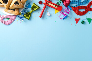 Purim celebration concept. Flat lay composition with hamantaschen cookies, masks, noisemaker, and...