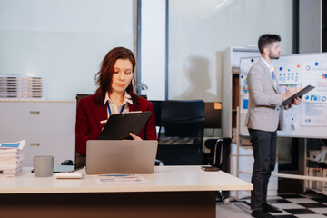 Financial analysts work overtime analyzing data on tablets, laptops, and graphs.