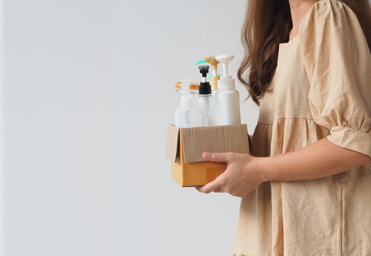 Woman hand holding box of plastic bottles and jar for refill liquid soap, shampoo and other products. Zero waste. Reuse reduce recycle concept.