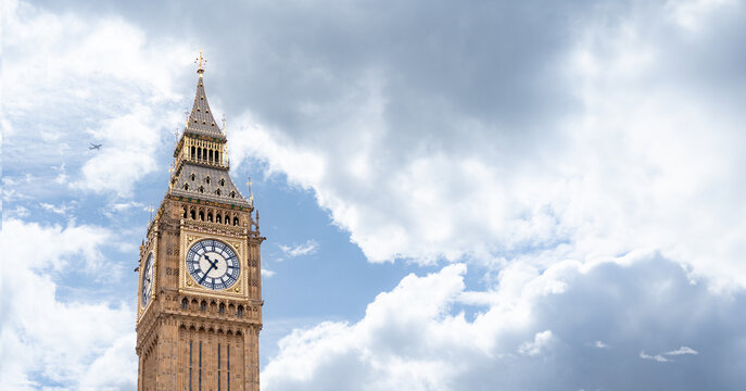 Big Ben iconic clock tower bathed in daylight, emphasizing the golden accents and intricate design against the backdrop of a cloudy sky, for promoting London historic landmarks.