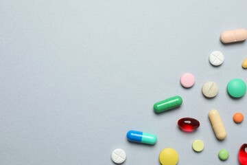Various pills on gray background, top view