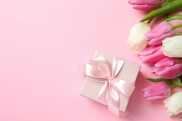 Beautiful fresh tulips with gift on color background