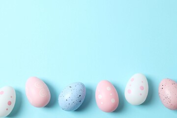 Happy Easter. Colorful eggs on a pastel blue background, space for text or advertising