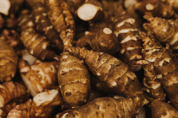 Group of fresh jerusalem artichokes background. Jerusalem artichokes or sunroot or sunchoke. Vegetarian food. Close-up, top view