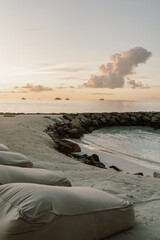 Relaxing beachfront lounge area with cozy outdoor seating overlooking a stunning overwater villas...