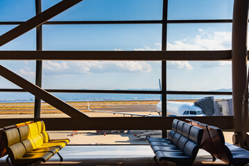 Airport terminal glass window with view of airplane, airport interior departure hall for travel and...