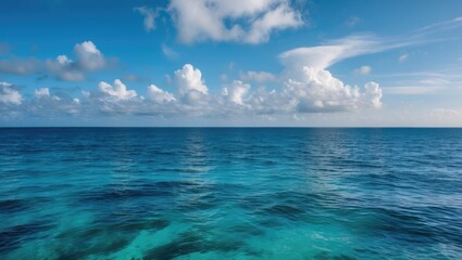 Fototapeta premium Vast ocean horizon under a blue sky with fluffy white clouds reflecting on water surface Copy Space