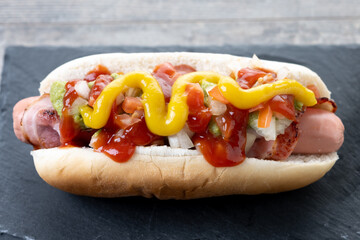 Sonoran hot dog. Traditional Mexican hot dog on wooden table