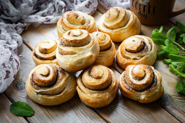 Cinnamon rolls for dessert. Sweet rolls for breakfast on a wooden table. Close-up